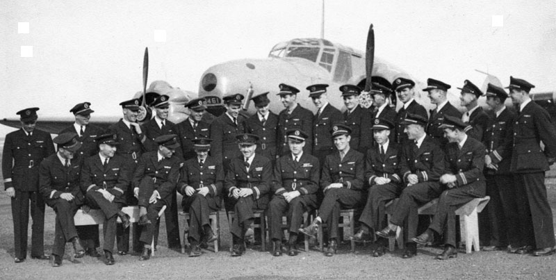 Photo: June 1941 class, No. 2 Air Observers School, #7 Hangar, Edmonton, Alberta, with Mark I Avro Anson behind them.